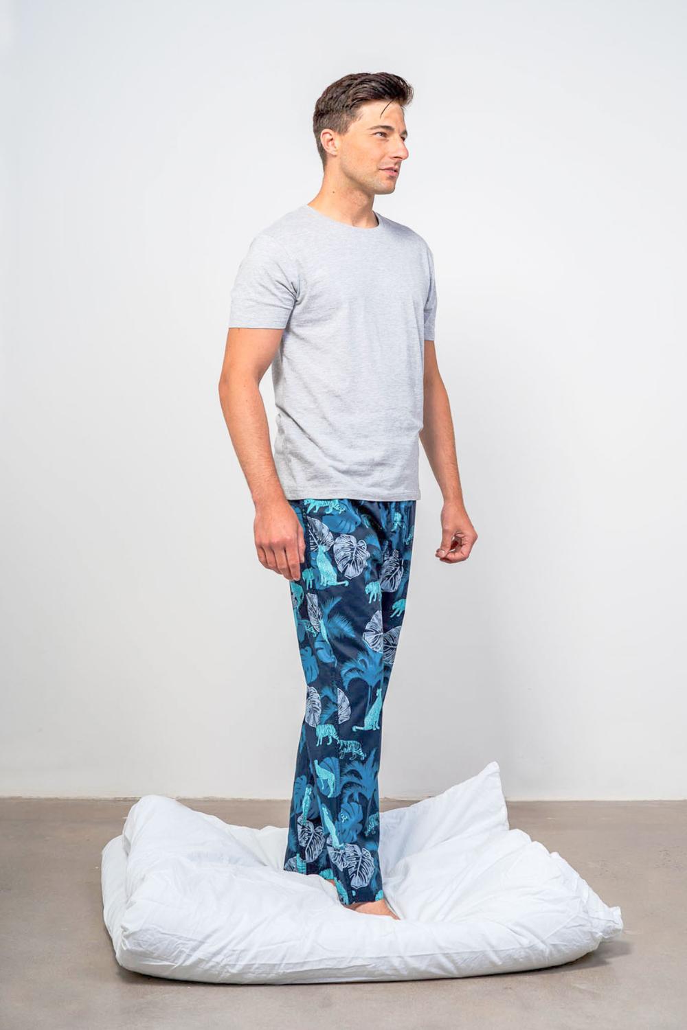 Model wearing the tropics tropical printed blue mens pyjama bottoms and grey organic t-shirt