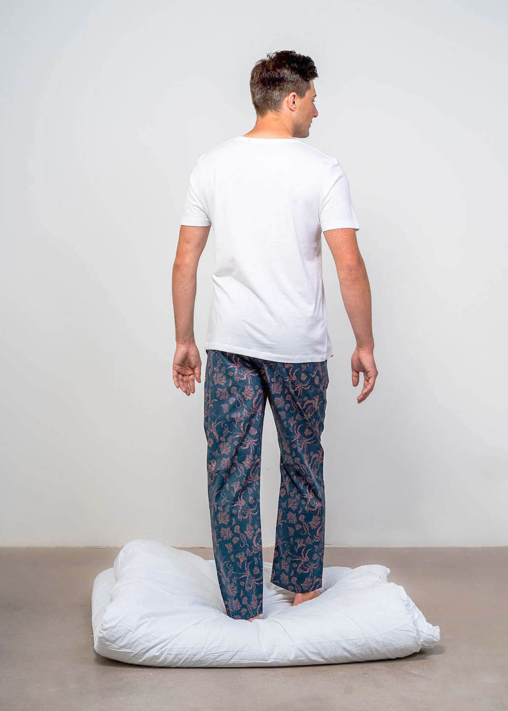 Back of model wearing long sleepwear bottoms blue and dusty pink
