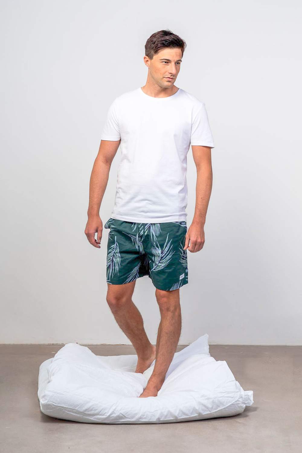 Model wearing green pyjama shorts with white organic cotton sleepwear t-shirt